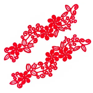 Détail d'un écusson brodé en dentelle florale rouge avec motif ajouré complexe