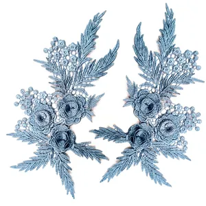 Close-up detail of a pair of blue 3D water-soluble lace floral patches for DIY fashion