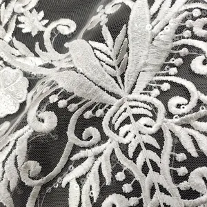 Dettaglio macro dell'elegante toppa in pizzo bianco ricamato con paillettes per sposa