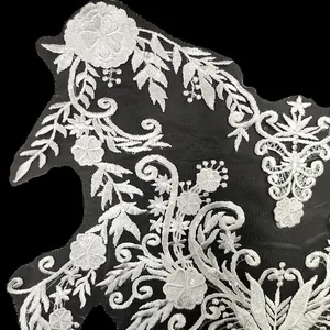 Dettaglio applicazione in pizzo floreale ricamato con paillettes per spose