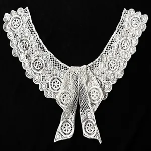 Macro view of white water-soluble lace collar featuring detailed floral embroidery