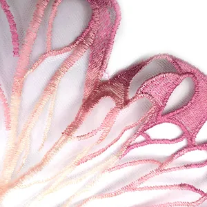 Macro close-up detail of pink gradient butterfly embroidery on fine white mesh fabric