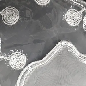 Detailed macro view of white organza embroidery lace with silver sequins and mesh