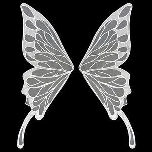 Detailed macro view of white embroidered butterfly wing lace applique on black background