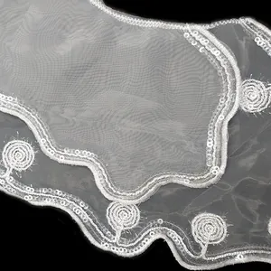 Detailed close-up view of white organza lace collar featuring sequin embroidery and wavy edges