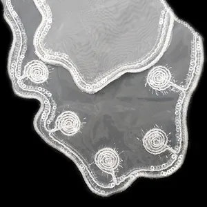 Detail view of white organza embroidered lace collar with shiny sequins and embroidery