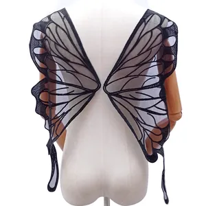 Detail view of large black butterfly wing embroidered lace applique on a mannequin.