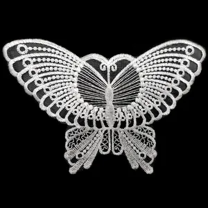 Detailed macro view of white embroidered butterfly patch showing intricate lace texture