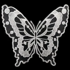 High-definition close-up of intricate white butterfly embroidery lace patch on black organza