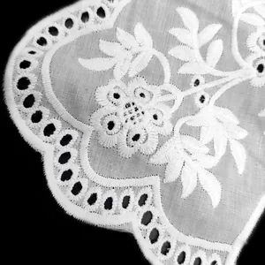 Macro detail of white floral eyelet embroidery lace collar with intricate stitching