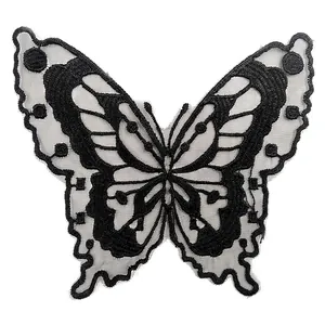 Detailed macro shot of a black butterfly embroidered patch on translucent organza mesh
