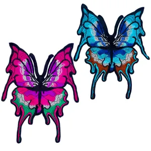 Close-up of vibrant pink and blue butterfly embroidery patches with intricate lace texture