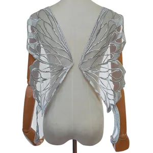 Macro view of silver butterfly wing lace embroidery applique on a mannequin
