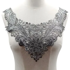 Vue détaillée du col en dentelle brodée argentée avec motifs floraux métalliques.