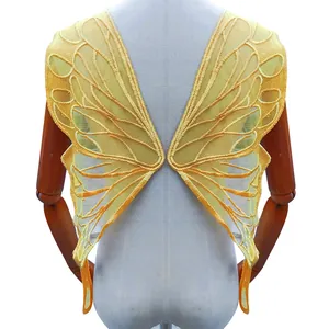 Detailed close-up of large yellow embroidered butterfly wing lace applique for lingerie decoration.