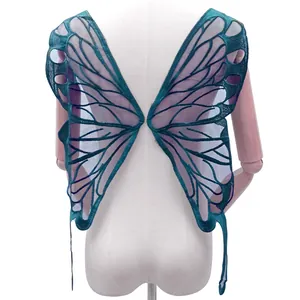 Detail of large dark teal butterfly wing lace embroidery patch on a white mannequin back