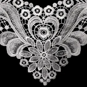 Gros plan d'un col en dentelle blanche hydrosoluble avec broderie florale en cœur