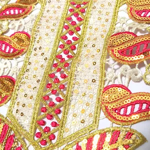 Détail macro du col en dentelle brodée avec des paillettes dorées brillantes