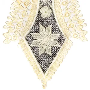 Détail macro d'une applique en dentelle crème avec broderie florale et maille ajourée