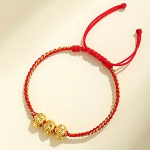Braccialetto in filo rosso intrecciato a mano con tre ciondoli a forma di serpente dorati