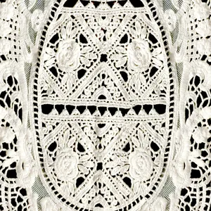 Close-up of white cotton lace embroidery with intricate hollow-out floral patterns