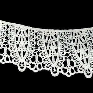 Close-up of white water-soluble lace embroidery trim on black background