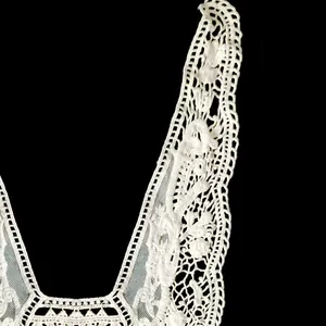 Macro detail of white water-soluble embroidered cotton lace collar with floral patterns