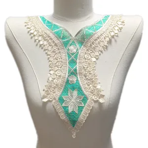 Gros plan d'un col en dentelle brodée turquoise et blanc avec fleurs sur un mannequin