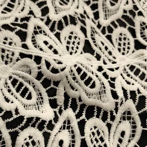 Macro view of white milk silk embroidery lace featuring hollow butterfly floral pattern