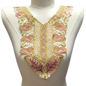 Vue détaillée d'un col en dentelle brodée rose et or avec des paillettes scintillantes