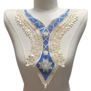 Détail de l'applique d'encolure en dentelle florale brodée beige et bleu sur mannequin