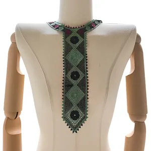 Detailed view of green embroidered lace collar patch in tie shape with floral patterns