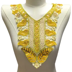Gros plan d'une broderie à paillettes jaunes sur une applique de col en dentelle soluble