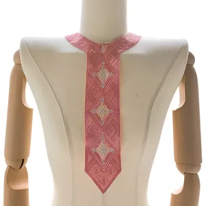Detailed view of pink embroidered lace false collar patch with geometric patterns on a mannequin