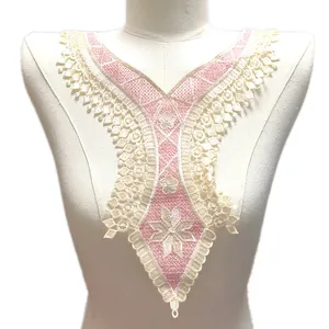 Détail rapproché d'un faux col en dentelle brodée rose et crème avec motif floral