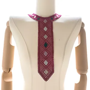 Close-up of magenta embroidered lace tie-shaped collar patch with geometric patterns