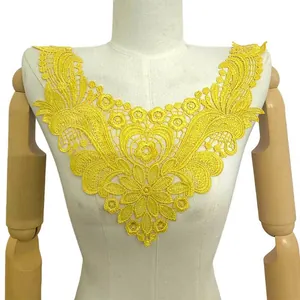 Détail d'une applique de col en dentelle jaune soluble sur un buste de mannequin blanc