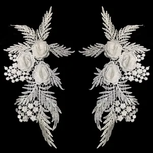 Detailed macro view of white 3D floral lace appliques with intricate embroidery patterns