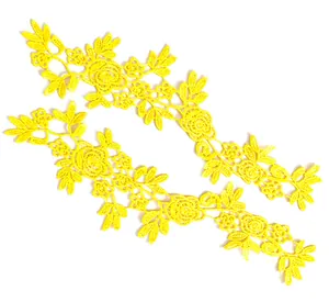 Detailansicht von zwei symmetrischen gelben floralen Spitzenapplikationen für Kleidung