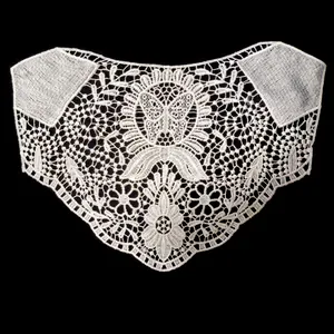 Detailed view of white water-soluble lace applique with intricate butterfly and flower patterns