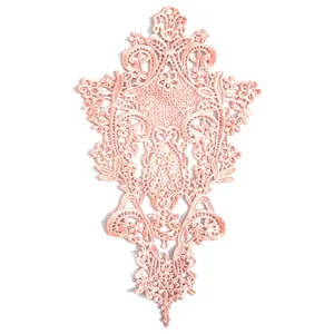 Primo piano di elegante toppa in pizzo ricamato rosa con motivi floreali decorati.