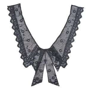 Detailed close-up of a black water-soluble lace collar with bow design and floral embroidery