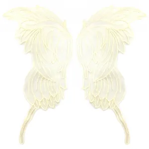 Detailed view of symmetrical beige embroidered lace wing patches for DIY crafts