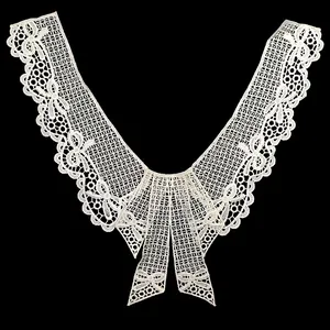 Macro detail showing intricate white water-soluble lace collar with bowknot embroidery patterns