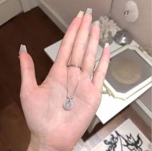 Elegante collana in argento sterling S925 con ciondolo in agata bianca tenuta in mano