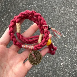 Detailed view of red hand-woven Chinese style bracelet featuring Shan Gui Hua Qian coin