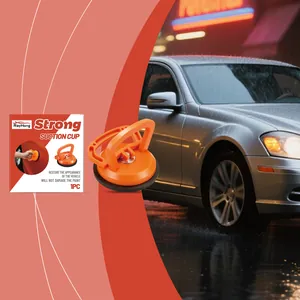 Close-up of orange car dent puller with retail packaging for vehicle repair.