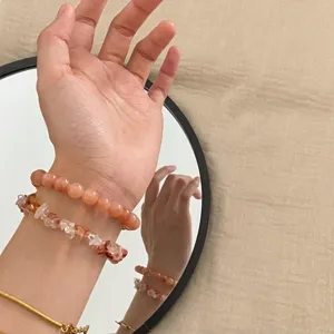Nahaufnahme von geschichteten Natursteinarmbändern mit Perlen und Chips.