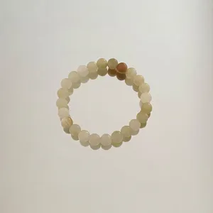Nahaufnahme eines handgefertigten Aventurin-Jade-Perlenarmbands in Pastellfarben.
