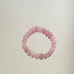 Detailansicht eines handgemachten Armbandes aus rosa Natursteinen mit Glanz
